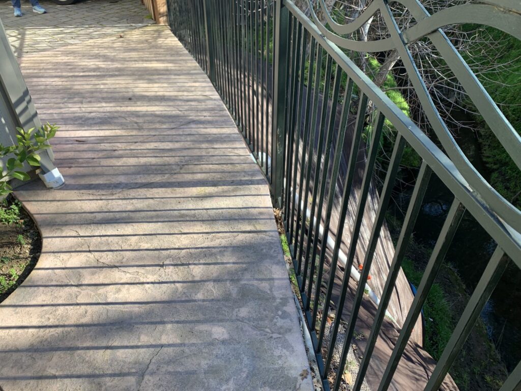 Completed Project This v The 20 foot area extending down to the creek bed beneath the ornamental iron guardrail has been armored with a tarp to prevent future erosion problems